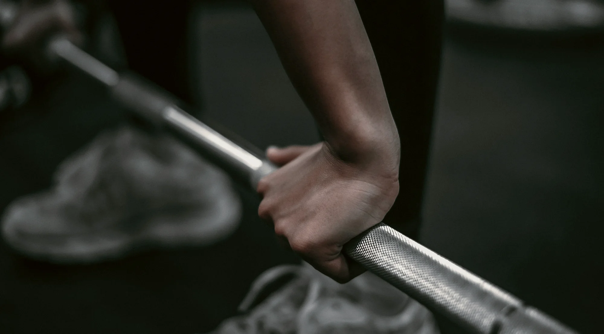 A hand closing its grip on the knurling of a steel bar